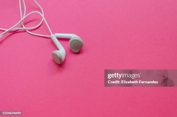 headphones on a pink background - hands free device foto e immagini stock