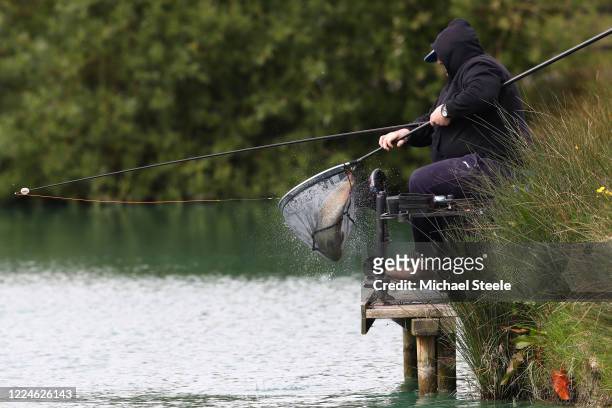 An angler nets a carp at Acorn Fisheries on May 13, 2020 in Kingston Seymour, Somerset, England . The prime minister announced the general contours...