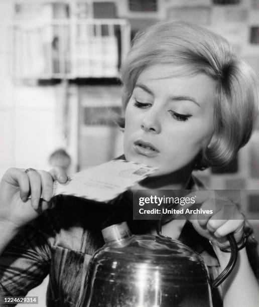 Austrian actress Heidelinde Weis opening a letter with water steam, Germany, 1960s. .