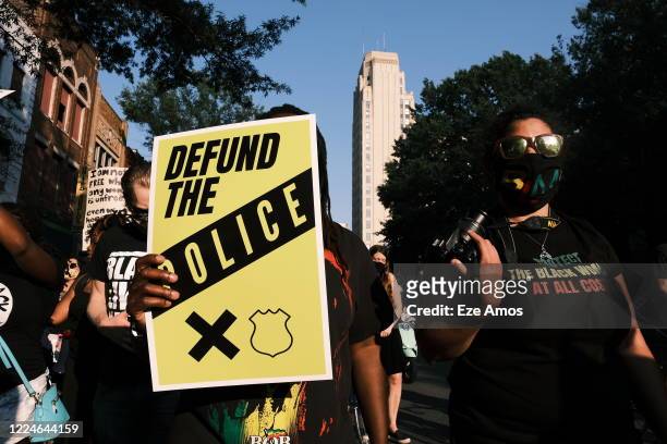 Protester carries a sign that reads "Defund The Police" during the Black Women Matter "Say Her Name" march on July 3, 2020 in Richmond, Virginia....