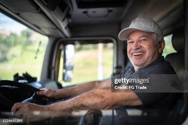 portrait of a senior male truck driver sitting in cab - old truck imagens e fotografias de stock