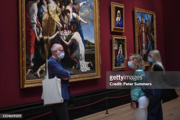 Group of people are seen wearing masks while viewing paintings at the National Portrait Gallery during a press preview ahead of the gallery's...