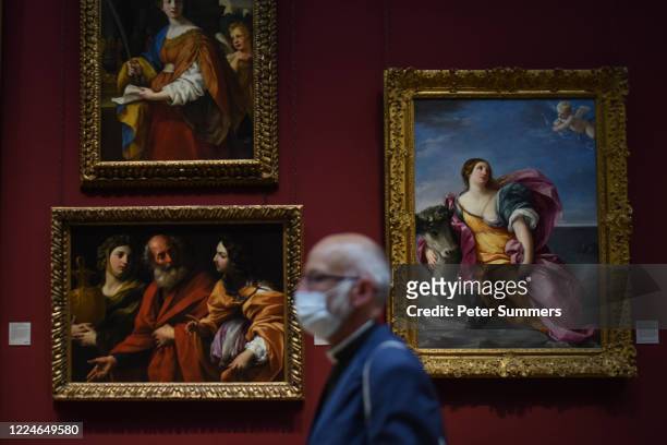 Man is seen wearing a mask while viewing paintings at the National Portrait Gallery during a press preview ahead of the gallery's reopening on July...