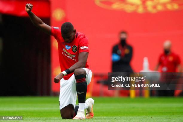Manchester United's French midfielder Paul Pogba takes a knee to show support for the Black Lives Matter movement and protest against racism during...
