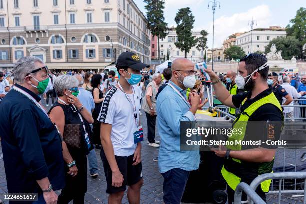 Staff member uses a thermoscanner to check the body temperature of the people taking part in the the demonstration organized by Lega Political party,...