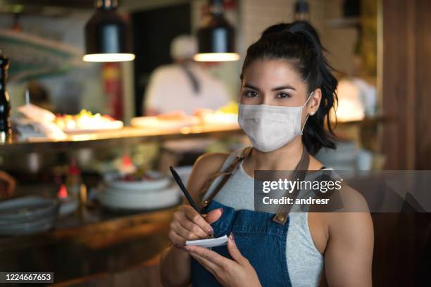 beautiful waitress working at a restaurant wearing a facemask - covid-19 business stock pictures, royalty-free photos & images