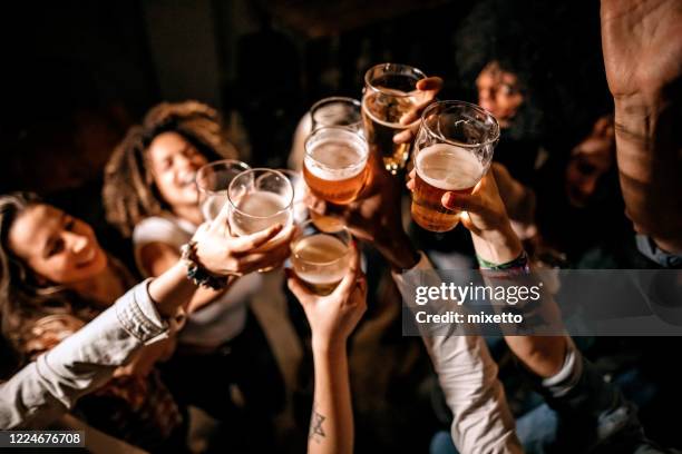 amigos brindando en el pub - brindis fotografías e imágenes de stock