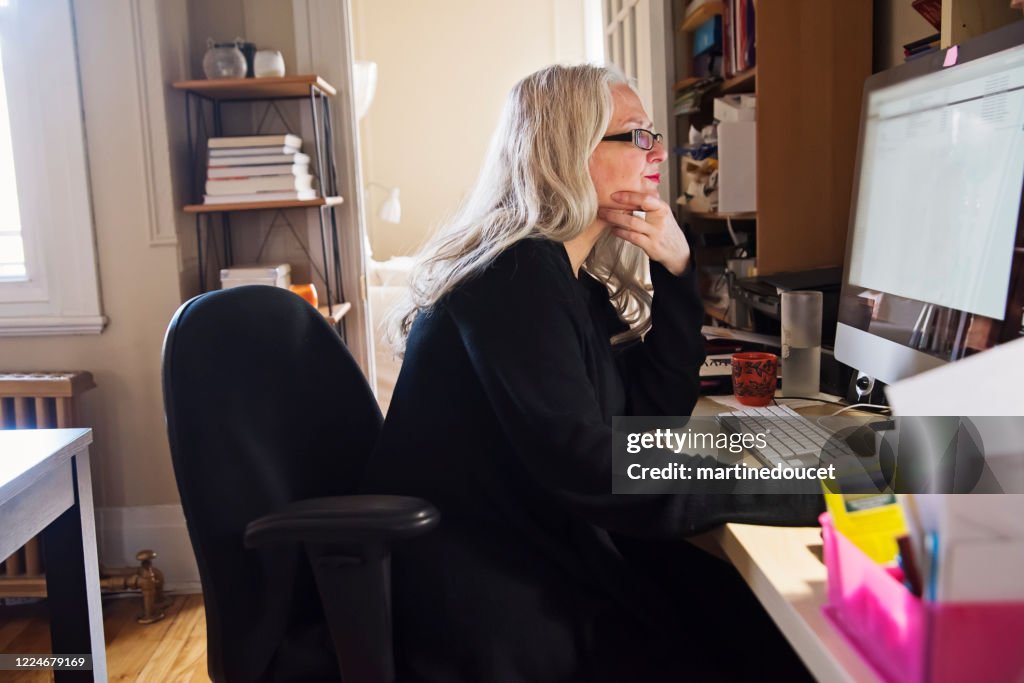 Elegante 50+ mujer trabajando desde casa.