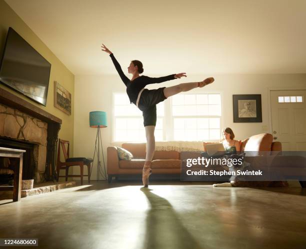 professional ballerina is executing an arabesque in her parents home on point - animal related occupation 個照片及圖片檔