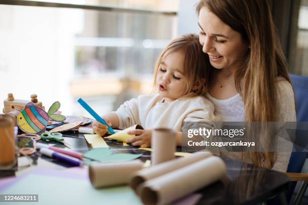 mother and preschool daughter learning and doing creative work - child drawing job imagens e fotografias de stock