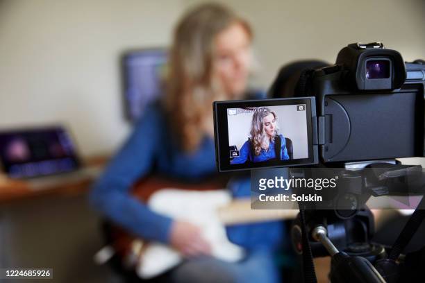 teenage girl recording herself on camera playing the guitar - visor digital imagens e fotografias de stock