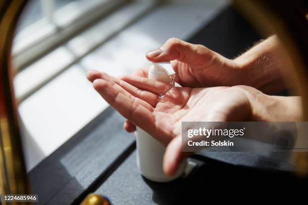 young man washing hands - gel antiséptico fotografías e imágenes de stock