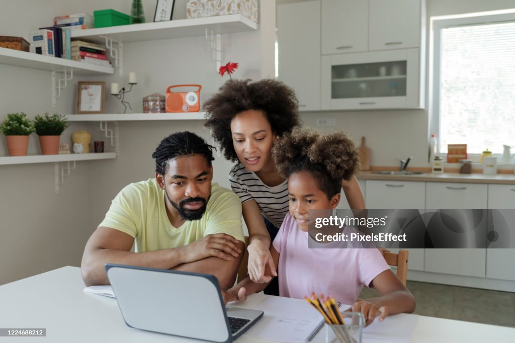 Eltern helfen ihrer Tochter bei der Hausaufgabenarbeit