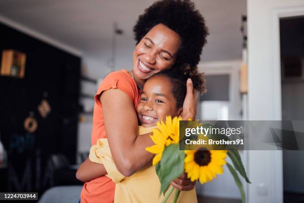 beautiful little girl giving her mother a mother's day present - flower presents stock pictures, royalty-free photos & images