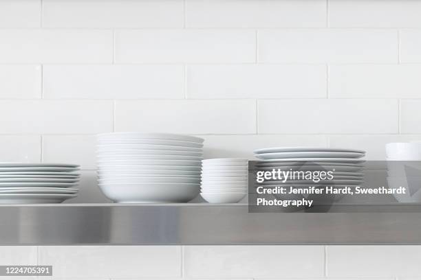 stacks of white dishes against white subway tile - ディッシュ ストックフォトと画像