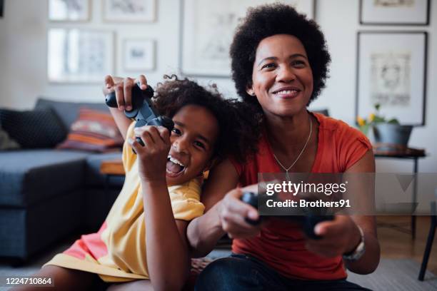 front view of a mother and daughter playing video games together - toy adult stock pictures, royalty-free photos & images