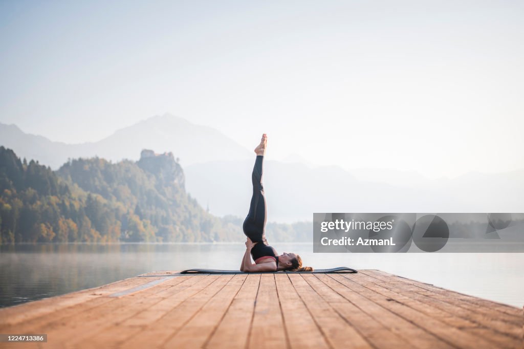 Woman in Supported Shoulder Stand Overlooking Lake Bled