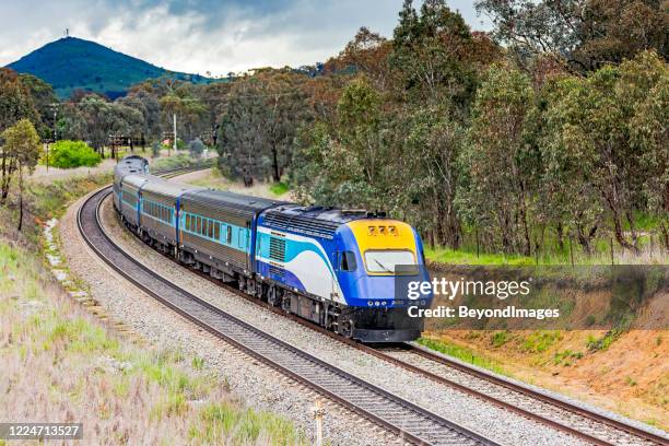 xpt aerodynamic diesel passenger train in hilly rural landscape - melbourne train stock pictures, royalty-free photos & images