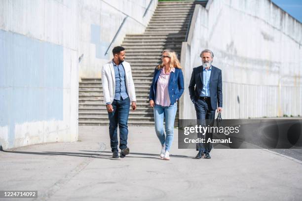 business colleagues walking in sunny urban location - man talking to camera stock pictures, royalty-free photos & images