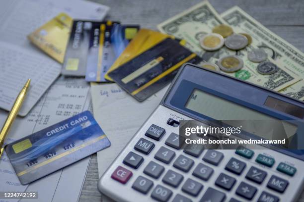 calculating monthly expenses for credit card debt with banknotes - debt collector stock-fotos und bilder