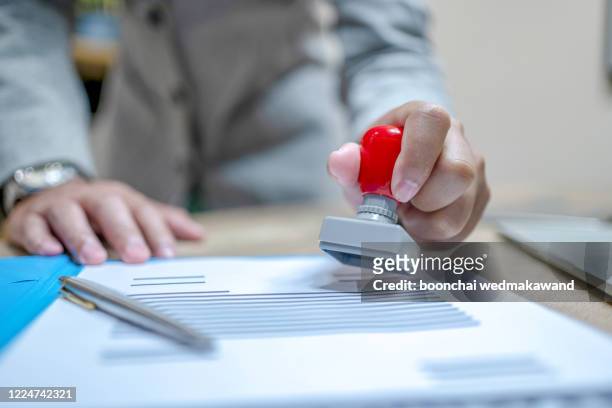 businessman stamping the document at the desk. - migration bildbanksfoton och bilder
