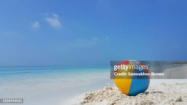 beach ball on white sandy beach and beautiful tropical sea - ゴムボール ストックフォトと画像