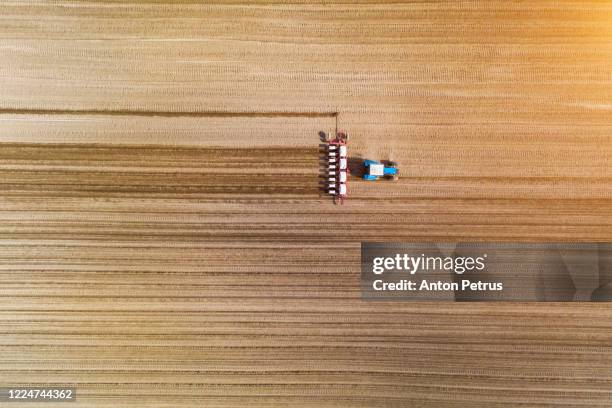 aerial view of tractor with mounted seeder on the field - cereal overhead stock pictures, royalty-free photos & images