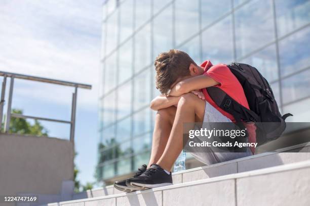 sad school boy with head in his lap - one teenage boy only stock pictures, royalty-free photos & images