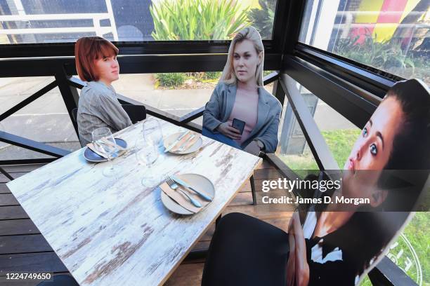 Cardboard cutouts of human beings sitting at tables inside the Five Dock Dining restaurant on May 14, 2020 in Sydney, Australia. Restaurants and...