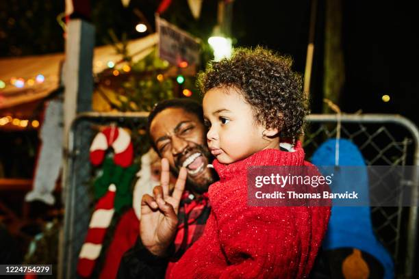 smiling father holding toddler son while shopping for christmas tree - opening night of bb forever brigitte bardot the legend stockfoto's en -beelden