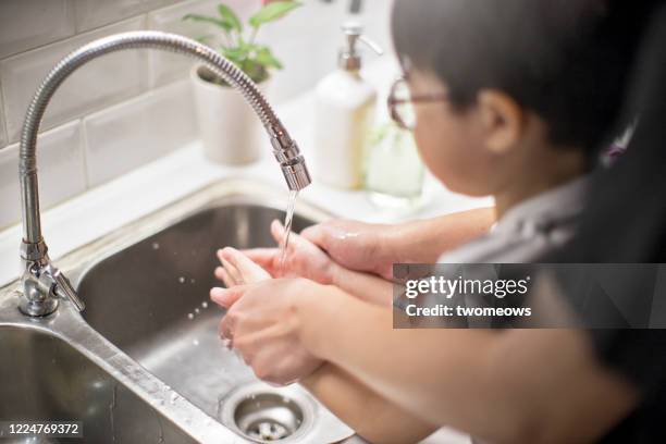 home hand washing and disinfection lifestyle image - child washing hands stockfoto's en -beelden