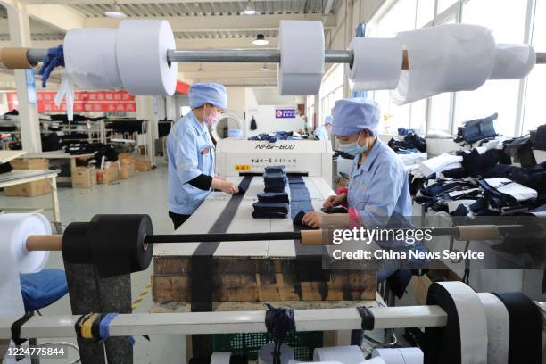 Employees make work suits at a garment factory operated by China National Nuclear Corporation on May 14, 2020 in Tongxin County, Ningxia Hui...