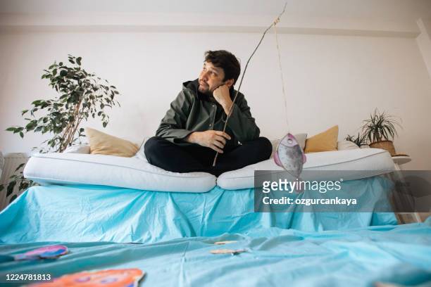 go fishing while in my living room. having fun while staying at home. - holiday sadness stock pictures, royalty-free photos & images