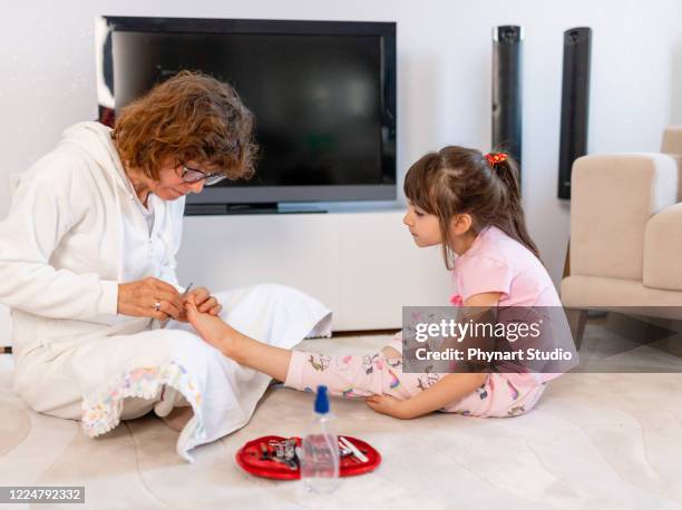 mother doing pedicure to her daughter at home - nail file stock pictures, royalty-free photos & images