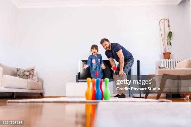 vater und tochter spielen zu hause bowling - family bowling stock-fotos und bilder