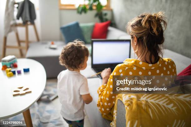 modern mom working from home with her son - back cushion stock pictures, royalty-free photos & images