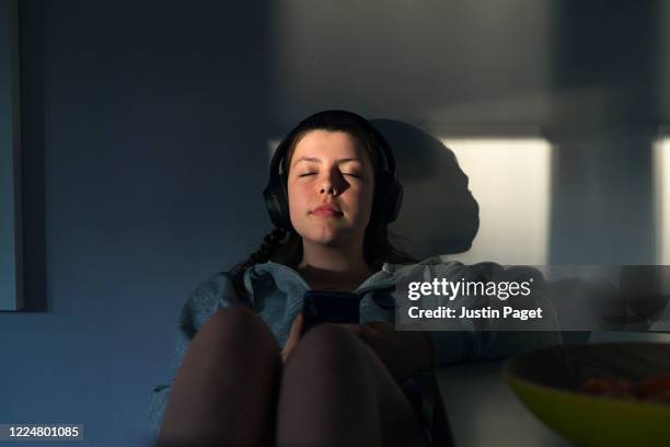 teenage girl listening to music - erleichterung stock-fotos und bilder