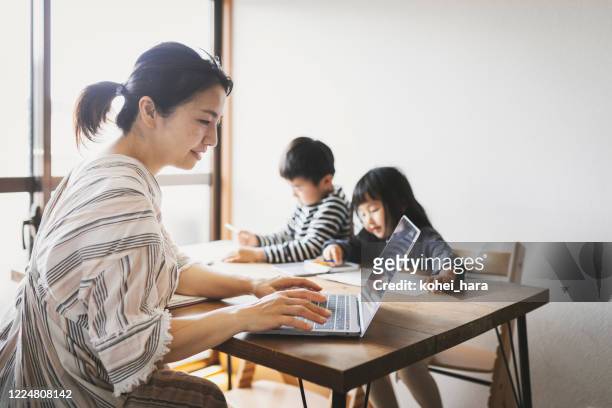 Mother working from home with children