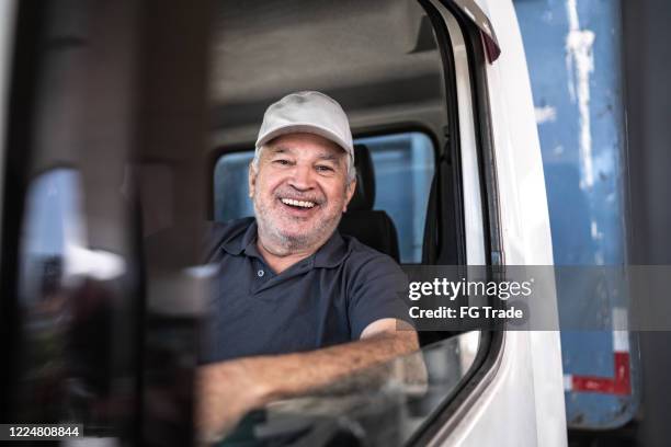 portrait of a senior male truck driver sitting in cab - old truck imagens e fotografias de stock