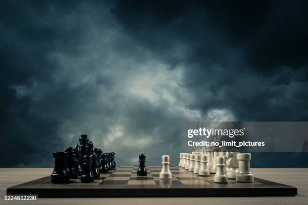 apertura de ajedrez frente a las nubes de tormenta - tablero de ajedrez fotografías e imágenes de stock