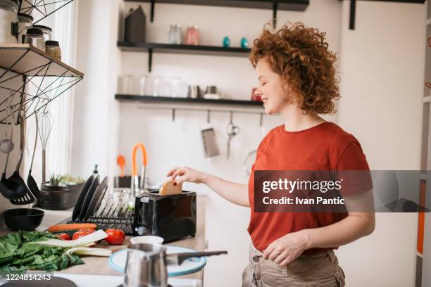 happy young redhead woman during her early morning ritual - toaster stock pictures, royalty-free photos & images