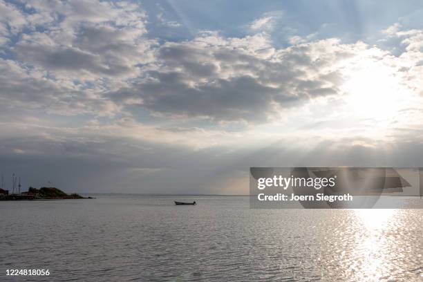 einsames boot auf dem meer - dramatischer himmel stock pictures, royalty-free photos & images