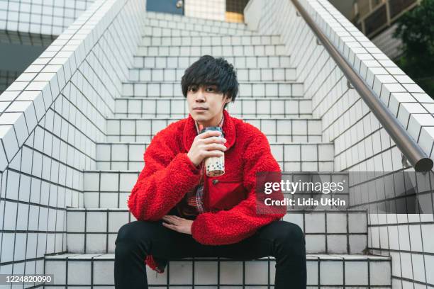 young man with bubble tea looking at camera - fashionable asian stock pictures, royalty-free photos & images