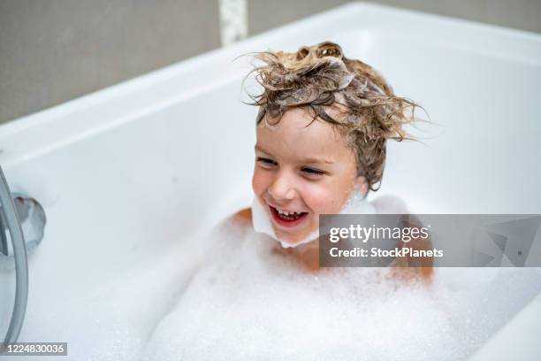 lächelnder junge hat spaß in der badewanne - boy taking a shower stock-fotos und bilder