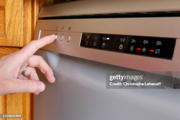 man turning on his dishwasher - máquina de lavar louça imagens e fotografias de stock