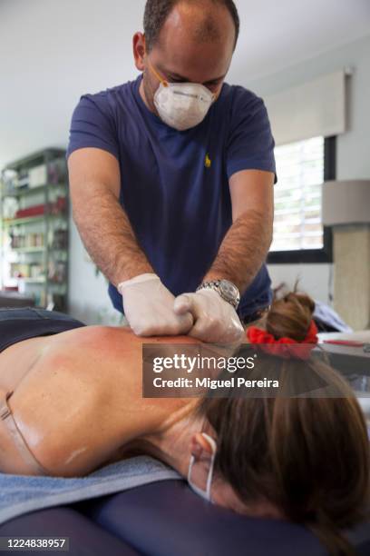 Physiotherapist Sergio Perdiguero perfoms a deep-tissue therapeutical massage at the home of the patient Virginia Bejar, the photographer's partner,...