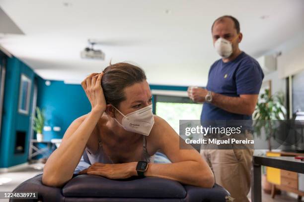 Physiotherapist Sergio Perdiguero perfoms a deep-tissue therapeutical massage at the home of the patient Virginia Bejar, the photographer's partner,...