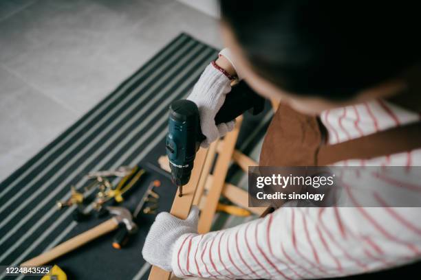 asia women building a table in home - diy woman stock-fotos und bilder