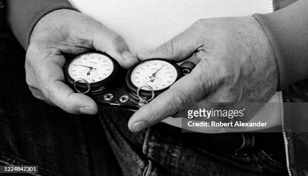 Veteran NASCAR driver and car owner Junior Johnson uses a stopwatch to time his car's speed around the racetrack during a practice session prior to...