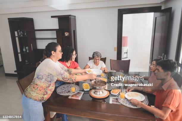 familie mittagessen am esstisch serviert mit feijoada, typisch brasilianischen schwarzen bohnen eintopf - brazilian feijoada dish stock-fotos und bilder